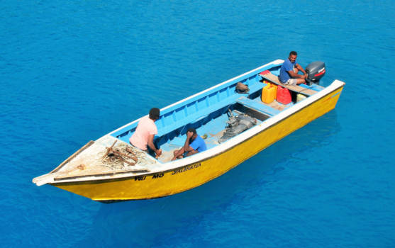 Fiji - Bootje varen in de zon op de blauwe zee van Fiji